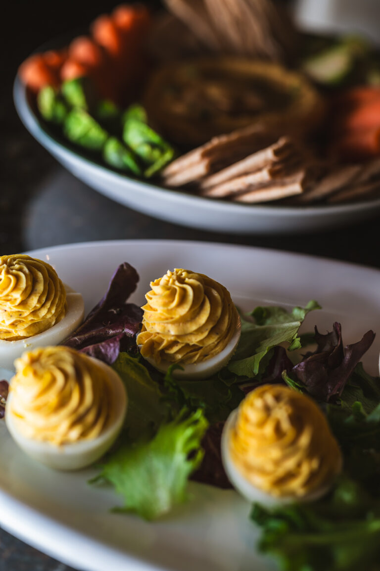 pumpkin deviled eggs with smoked paprika and cumin on a dark slate board