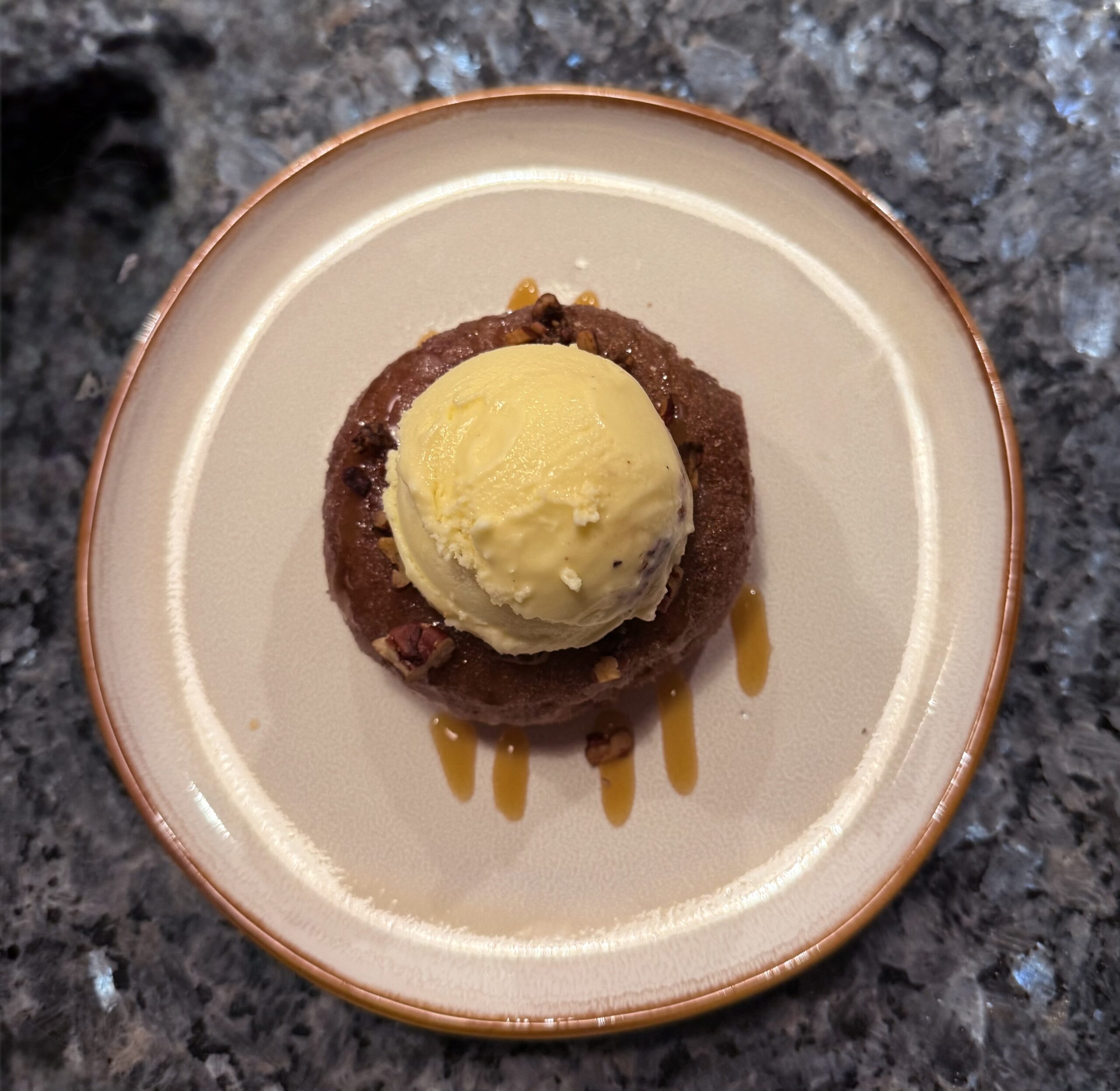 Apple Cider Donuts on a white plate with caramel and pecans
